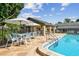 Poolside lounging and dining area with tables, umbrellas and chairs provide a relaxing space with lots of shade at 3151 Landmark Dr # 123, Clearwater, FL 33761