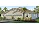Two-story house with a three-car garage, landscaping, and palm trees at 32688 Rustic Rise Rd, San Antonio, FL 33576