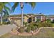 Tan one-story house with palm trees and landscaped yard at 335 Siena Vista Pl, Sun City Center, FL 33573