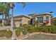 Tan one-story house with palm trees and landscaped yard at 335 Siena Vista Pl, Sun City Center, FL 33573