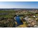 An aerial view of the property showcasing its proximity to a scenic lake, lush greenery, and the city skyline in the distance at 346 80Th Ne Ave, St Petersburg, FL 33702