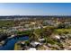 Aerial view of a two-story home surrounded by lush greenery and a tranquil lake with views of a distant cityscape at 346 80Th Ne Ave, St Petersburg, FL 33702