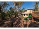 Spacious backyard featuring mature trees, a play structure with a slide, offering plenty of room for outdoor activities at 346 80Th Ne Ave, St Petersburg, FL 33702