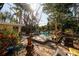 Backyard view featuring a wooden deck area with seating, set amid a green, landscaped yard at 346 80Th Ne Ave, St Petersburg, FL 33702