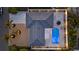 Aerial view showcases a house with a dark roof, a beautiful pool area, and meticulous landscaping at 4523 Clearwater Harbor S Dr, Largo, FL 33770