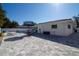 Well-maintained patio with a dining set and seating by a pool, complemented by lush landscaping and clear skies at 4523 Clearwater Harbor S Dr, Largo, FL 33770