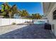 Backyard with a well-maintained patio, dining set, and inviting lounge chairs surrounding the swimming pool at 4523 Clearwater Harbor S Dr, Largo, FL 33770