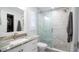 Elegant bathroom with a granite countertop sink and a glass-enclosed shower featuring mosaic tile flooring at 4523 Clearwater Harbor S Dr, Largo, FL 33770