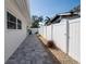 Exterior view shows the side yard with a well-maintained walkway and a white privacy fence at 4523 Clearwater Harbor S Dr, Largo, FL 33770