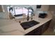 Modern kitchen sink with stylish faucet and white countertop, complemented by decorative objects on the windowsill at 4523 Clearwater Harbor S Dr, Largo, FL 33770