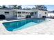 The backyard features a pool, patio and landscaped area bordered by a white vinyl fence for privacy at 4523 Clearwater Harbor S Dr, Largo, FL 33770