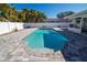 A sparkling backyard pool with stylish pavers, surrounded by lush landscaping and a privacy fence at 4523 Clearwater Harbor S Dr, Largo, FL 33770