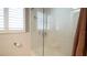 Tiled bathtub with a clear glass shower screen and white shutters on the adjacent window at 4523 Clearwater Harbor S Dr, Largo, FL 33770