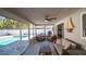 Relaxing sunroom with a sofa, chairs, ceiling fan, and glass doors overlooking the pool at 4523 Clearwater Harbor S Dr, Largo, FL 33770