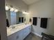Double vanity bathroom with gray tile floor and a large mirror at 493 Omen St, Punta Gorda, FL 33982