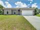 New construction home with gray exterior, two-car garage, and manicured lawn at 493 Omen St, Punta Gorda, FL 33982