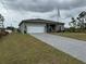 Exterior view of a house with a paved driveway and grassy lawn at 493 Omen St, Punta Gorda, FL 33982