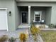 Front porch view of a house with a black door and seating area at 493 Omen St, Punta Gorda, FL 33982