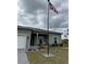 Front view of a single story house with a white garage door and American flag at 493 Omen St, Punta Gorda, FL 33982