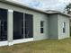 Rear view of a house with screened lanai and mature landscaping at 493 Omen St, Punta Gorda, FL 33982