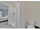 Bathroom with toilet and shower, plus a view into a bedroom at 5322 Fiddle Fig Ave, Wimauma, FL 33598
