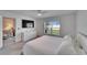 Bright bedroom with king-size bed, dresser, and views of the backyard at 5322 Fiddle Fig Ave, Wimauma, FL 33598