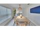 Dining room with wood table, bench, and wicker pendant light at 5322 Fiddle Fig Ave, Wimauma, FL 33598