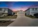 House exterior at dusk with driveway and landscaping at 5322 Fiddle Fig Ave, Wimauma, FL 33598