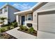 Front view of a house with gray door and attached garage at 5322 Fiddle Fig Ave, Wimauma, FL 33598