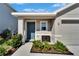 House entrance with gray door, landscaping, and walkway at 5322 Fiddle Fig Ave, Wimauma, FL 33598