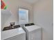 Functional laundry room with Whirlpool washer and dryer at 5322 Fiddle Fig Ave, Wimauma, FL 33598