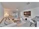 Bright living room featuring a large sectional sofa, coffee table, and large TV at 5322 Fiddle Fig Ave, Wimauma, FL 33598