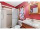 Compact bathroom featuring a walk-in shower, granite vanity top, and colorful walls at 5539 Regal Way, Zephyrhills, FL 33541