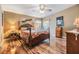 This cozy bedroom features a wooden four poster bed, ceiling fan, and hardwood floors at 5539 Regal Way, Zephyrhills, FL 33541