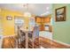 Cozy dining area with wood floors, stylish lighting and sunny yellow walls at 5539 Regal Way, Zephyrhills, FL 33541
