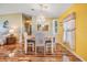 Inviting dining area featuring wood floors, a light fixture, and bright yellow walls at 5539 Regal Way, Zephyrhills, FL 33541