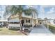 Charming single-story home featuring a covered carport, a cozy front porch, and a well-maintained lawn at 5539 Regal Way, Zephyrhills, FL 33541