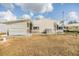 Exterior view of the property showcasing the lawn, and a covered patio area at 5539 Regal Way, Zephyrhills, FL 33541
