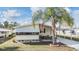 Inviting single-story home with covered awning, front patio seating and decorative palm tree at 5539 Regal Way, Zephyrhills, FL 33541