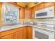 Close-up of a functional kitchen featuring wood cabinets and appliances at 5539 Regal Way, Zephyrhills, FL 33541