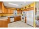 Bright kitchen with wood cabinets, white appliances, and a window over the sink at 5539 Regal Way, Zephyrhills, FL 33541