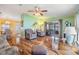 Open-concept living room featuring hardwood floors, recliners, and access to screened lanai at 5539 Regal Way, Zephyrhills, FL 33541