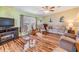 Cozy living room area with hardwood flooring, fireplace, television, and comfortable seating at 5539 Regal Way, Zephyrhills, FL 33541