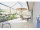 Large screened porch with wicker furniture and pond view at 5565 Salem Square N Dr, Palm Harbor, FL 34685