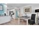 A dining area adjacent to the kitchen featuring wood floors, a rustic mirror, and white kitchen cabinets at 5623 80Th N St # 505, St Petersburg, FL 33709