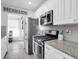 A stylish kitchen with white cabinets, stainless steel appliances, and a 