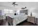 A serene bedroom with wood-look floors, a ceiling fan, and a decorative mermaid art piece above the bed at 5623 80Th N St # 505, St Petersburg, FL 33709