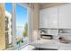 Bright workspace featuring a sleek white built-in desk, complemented by a window with views of water and a palm tree at 5633 Puerta Del Sol S Blvd # 306, St Petersburg, FL 33715