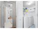 Functional laundry room with a washer, dryer, and shelving, with the main bathroom in the background at 5633 Puerta Del Sol S Blvd # 306, St Petersburg, FL 33715