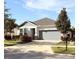 Single-story home with gray siding, two-car garage, and landscaped front yard at 6035 Plover Meadow St, Lithia, FL 33547